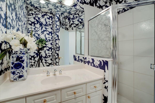 bathroom featuring a shower with door and vanity