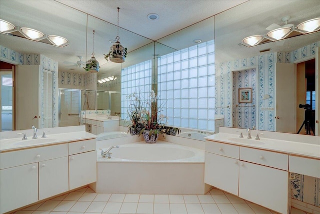 bathroom featuring ceiling fan, vanity, and plus walk in shower