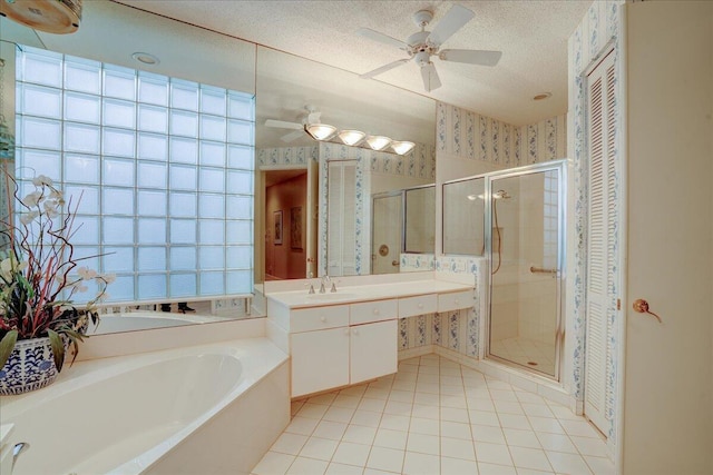 bathroom with shower with separate bathtub, a textured ceiling, vanity, ceiling fan, and tile patterned flooring