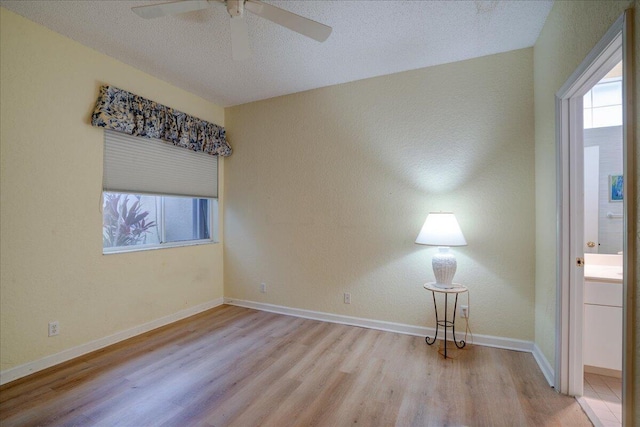 unfurnished room featuring light hardwood / wood-style flooring, ceiling fan, plenty of natural light, and a textured ceiling