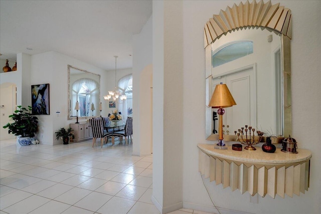 hallway with a notable chandelier and light tile patterned floors