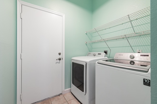 washroom featuring washing machine and dryer and light tile patterned flooring