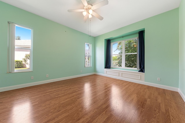 unfurnished room with wood-type flooring, a wealth of natural light, and ceiling fan