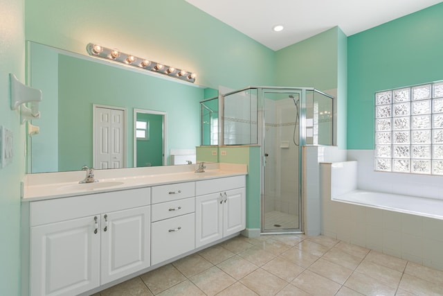 bathroom featuring tile patterned flooring, shower with separate bathtub, and vanity