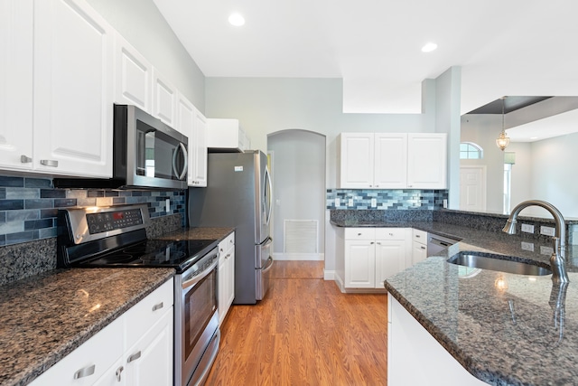 kitchen featuring stainless steel appliances, white cabinets, hanging light fixtures, and sink