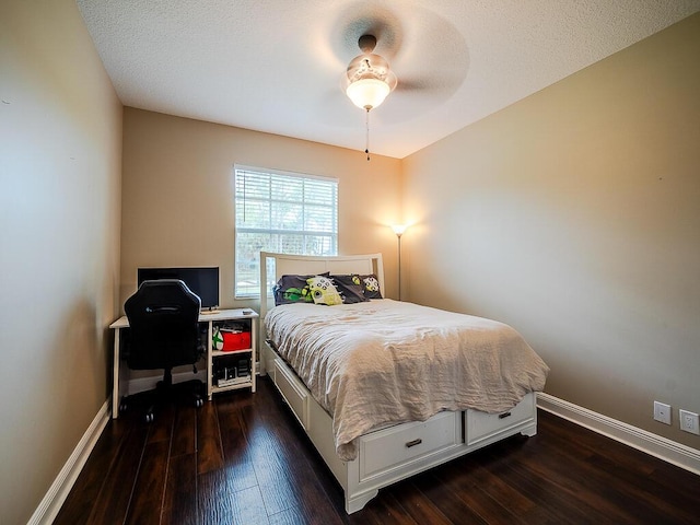 bedroom featuring dark hardwood / wood-style floors, a textured ceiling, and ceiling fan