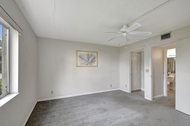 empty room featuring carpet floors, a textured ceiling, and ceiling fan