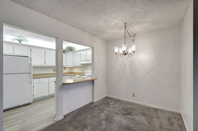 kitchen with white cabinetry, kitchen peninsula, a notable chandelier, decorative light fixtures, and white appliances