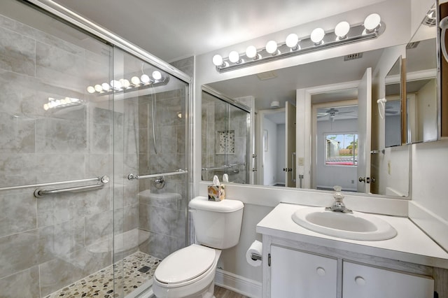 bathroom featuring vanity, toilet, and a shower with door