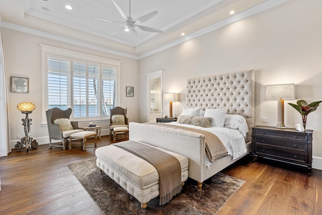 bedroom featuring a raised ceiling, crown molding, dark wood-type flooring, and ceiling fan