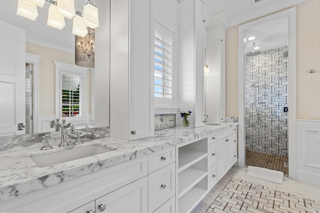 bathroom with crown molding, tiled shower, and vanity