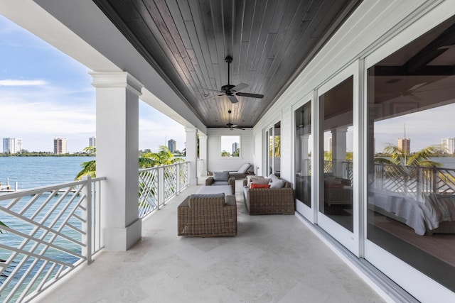 balcony with a water view and ceiling fan