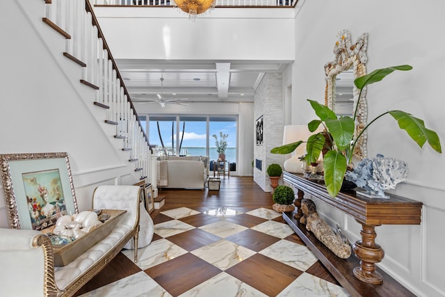 foyer entrance with beam ceiling, wood-type flooring, and ceiling fan