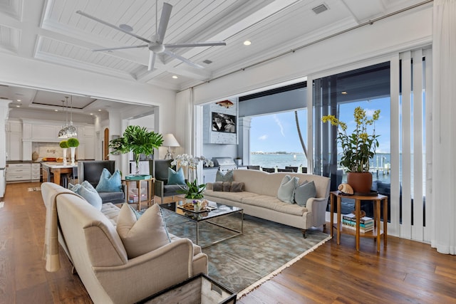 living room with ceiling fan, beam ceiling, a water view, coffered ceiling, and dark hardwood / wood-style flooring