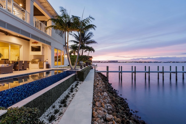 view of dock with a water view, area for grilling, and a balcony