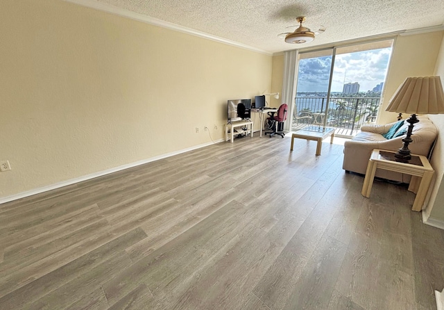 living room featuring hardwood / wood-style flooring, expansive windows, crown molding, and a textured ceiling