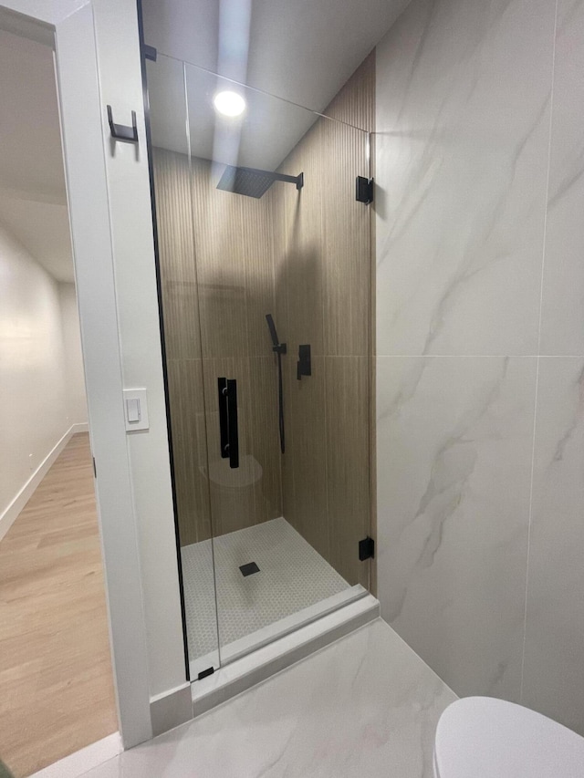 bathroom featuring toilet, wood-type flooring, and walk in shower