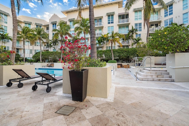 view of property's community with a pool and a patio