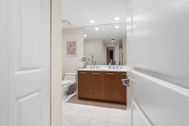 bathroom with toilet, vanity, and tile patterned floors