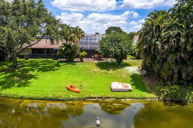 surrounding community featuring a water view and a lawn