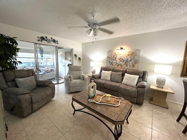 living room featuring ceiling fan, light tile patterned floors, and a textured ceiling