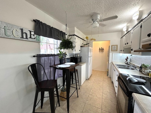 kitchen with ceiling fan, backsplash, white cabinets, and black / electric stove