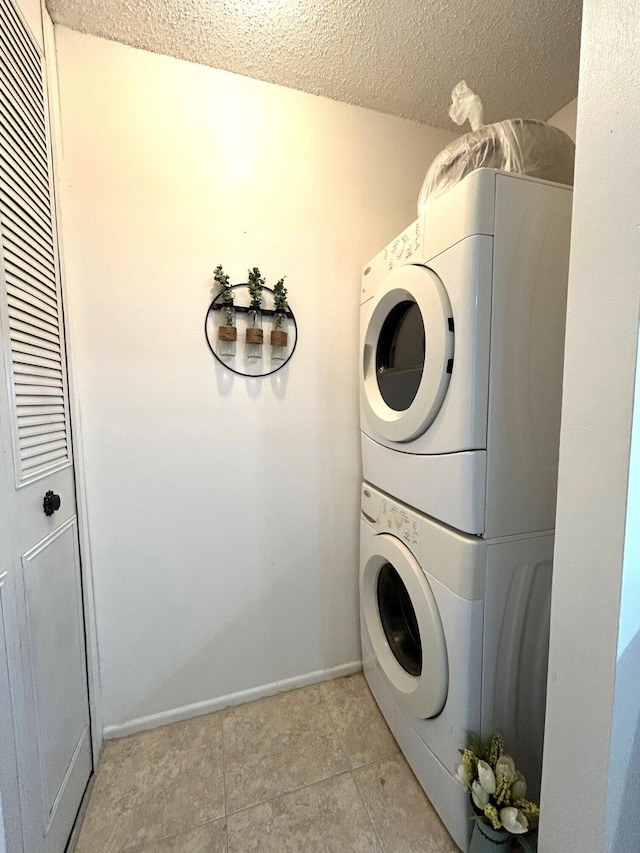 laundry room with stacked washer and clothes dryer and a textured ceiling