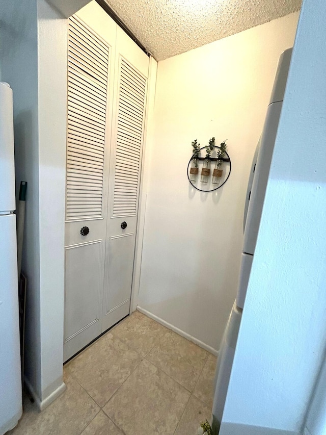 interior space with a textured ceiling and light tile patterned floors