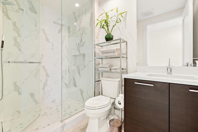 bathroom with tiled shower, vanity, toilet, and hardwood / wood-style floors