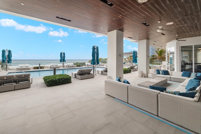 view of patio with a community pool, an outdoor hangout area, ceiling fan, and a water view