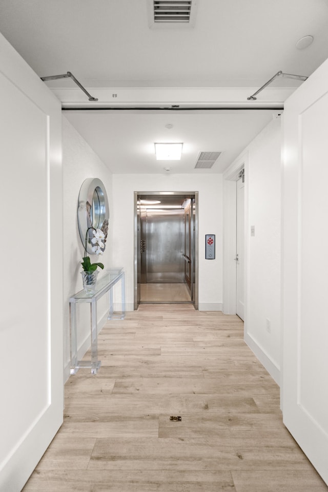 hall featuring light hardwood / wood-style flooring and elevator