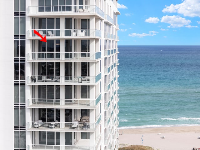 view of property with a water view and a beach view