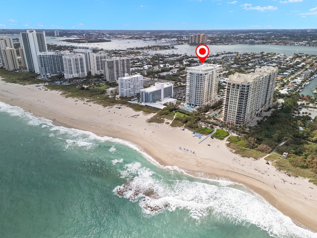 bird's eye view featuring a water view and a beach view