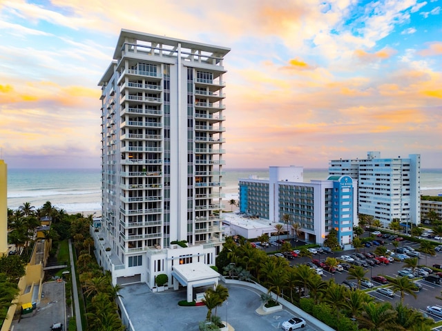 outdoor building at dusk with a water view and a view of the beach