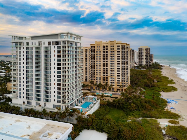 view of building exterior with a water view and a beach view