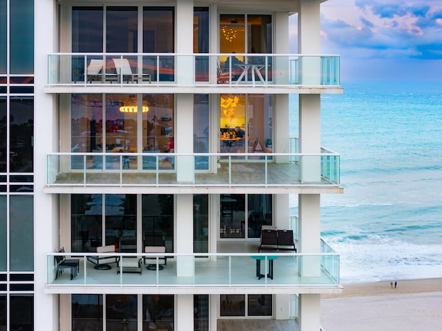 rear view of house with a water view and a beach view