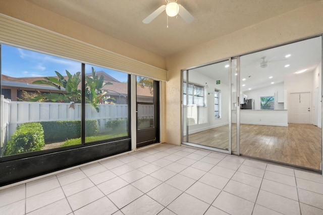 unfurnished sunroom with ceiling fan