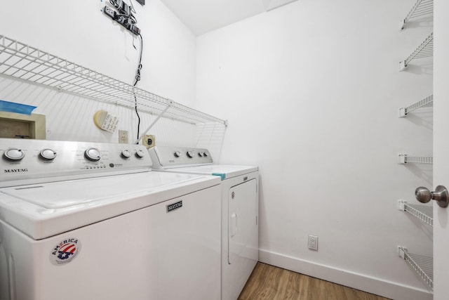 clothes washing area with hardwood / wood-style flooring and washing machine and clothes dryer