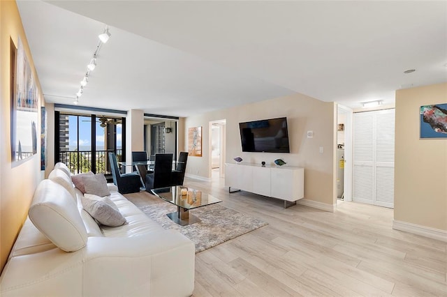 living room featuring expansive windows, track lighting, and light wood-type flooring