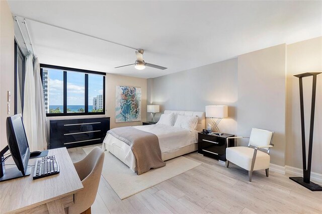 living area featuring a wall of windows, rail lighting, light wood-style floors, and baseboards