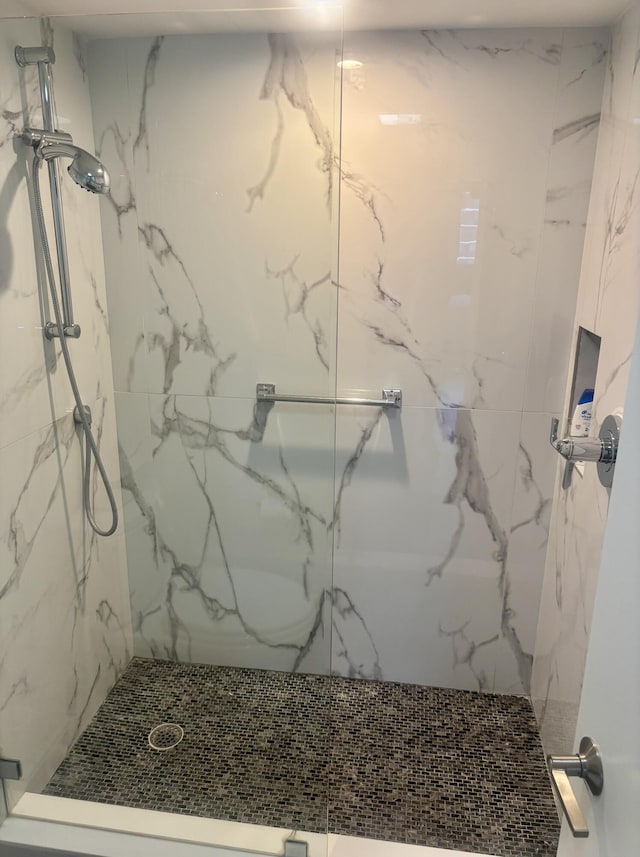 full bath with a marble finish shower