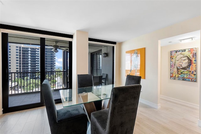 dining space featuring floor to ceiling windows, wood finished floors, and baseboards