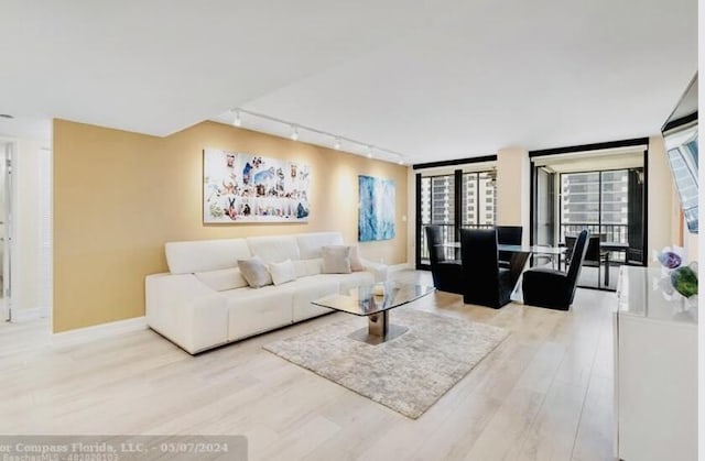 living area featuring baseboards and wood finished floors