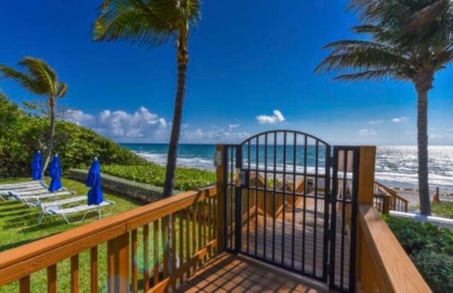 wooden terrace with a beach view and a water view