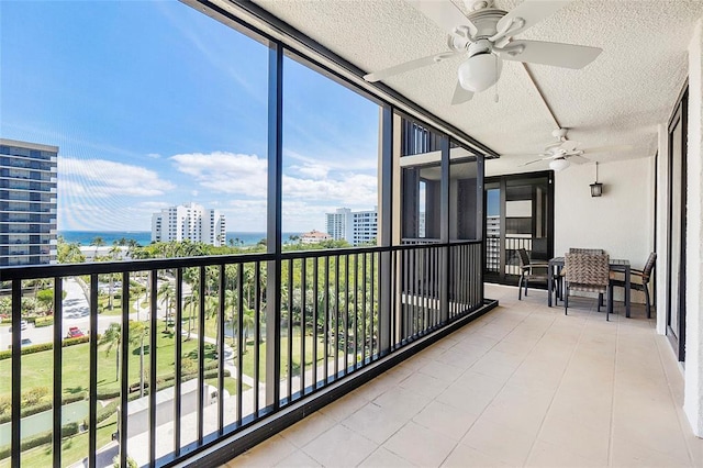 sunroom / solarium with a city view and ceiling fan