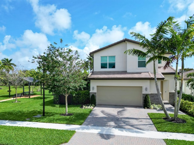 view of front of home with decorative driveway, an attached garage, stone siding, and stucco siding