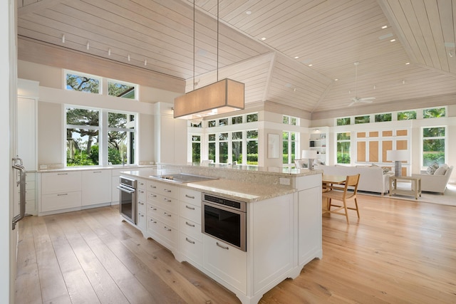 kitchen featuring pendant lighting, white cabinetry, high vaulted ceiling, light stone counters, and wooden ceiling