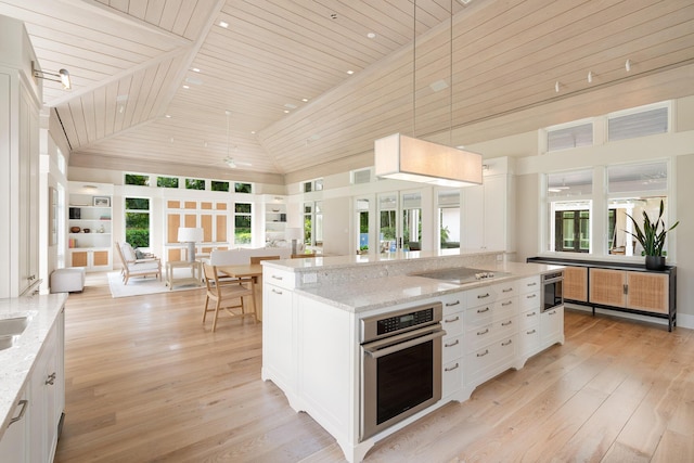 kitchen featuring pendant lighting, stainless steel oven, white cabinets, light stone counters, and wooden ceiling