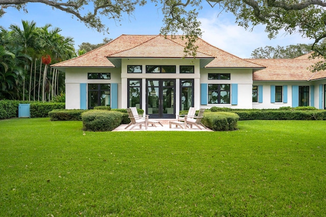 back of house featuring french doors, a lawn, and a patio