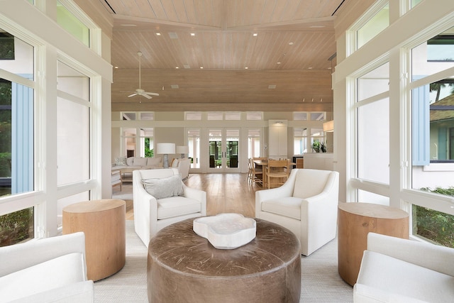 living room with ceiling fan, a towering ceiling, light wood-type flooring, french doors, and wooden ceiling